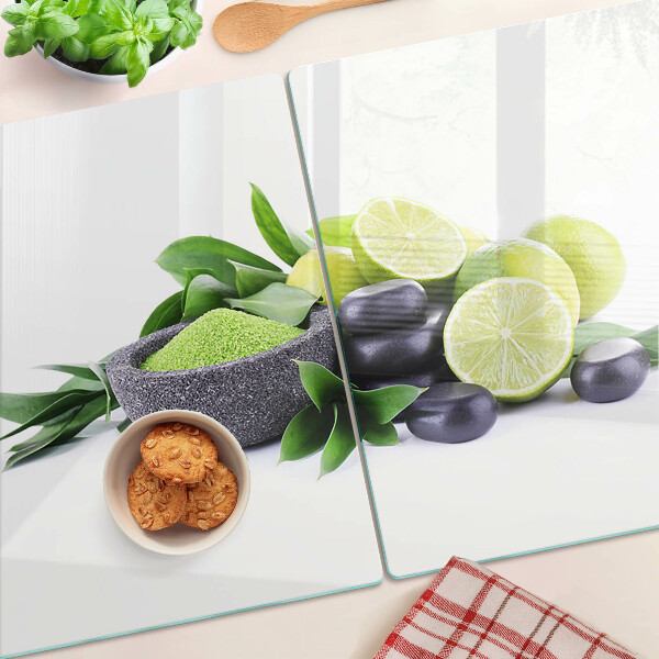 Snijplanken van glas Citroenen en druiven op een groene achtergrond