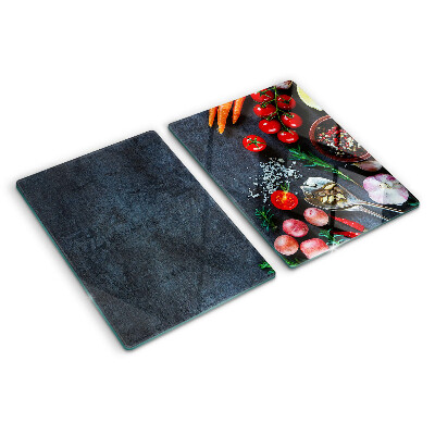 Snijplanken van glas Groenten en specerijen op een donkere achtergrond