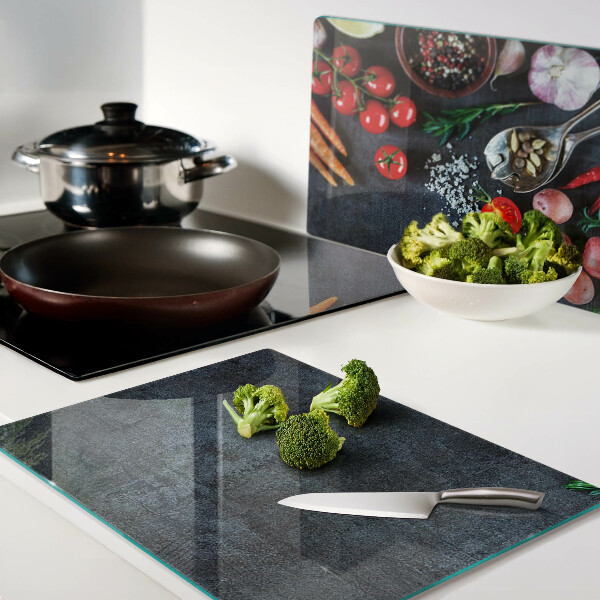 Snijplanken van glas Groenten en specerijen op een donkere achtergrond