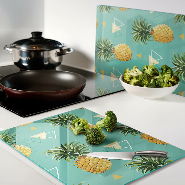 Snijplanken van glas Ananassen op een turquoise achtergrond