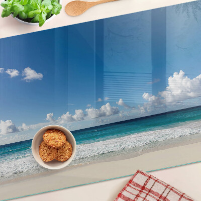 Snijplanken glas Een strand met turquoise water en wolken.