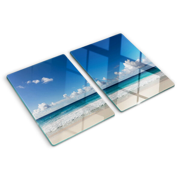 Snijplanken glas Een strand met turquoise water en wolken.