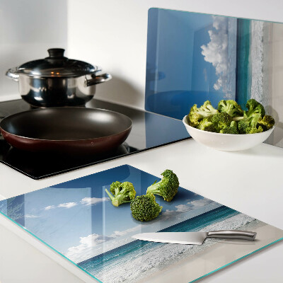 Snijplanken glas Een strand met turquoise water en wolken.