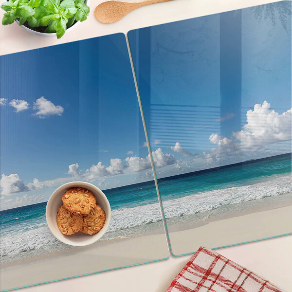 Snijplanken glas Een strand met turquoise water en wolken.