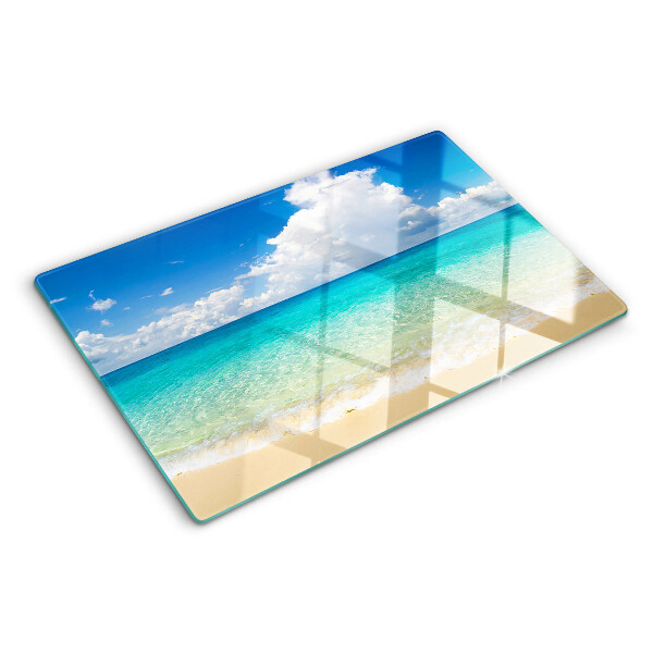Snijplanken van glas Een strand met turquoise water en wolken.