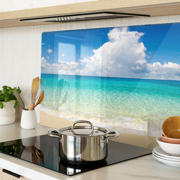 Snijplanken van glas Een strand met turquoise water en wolken.