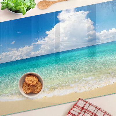 Snijplanken van glas Een strand met turquoise water en wolken.