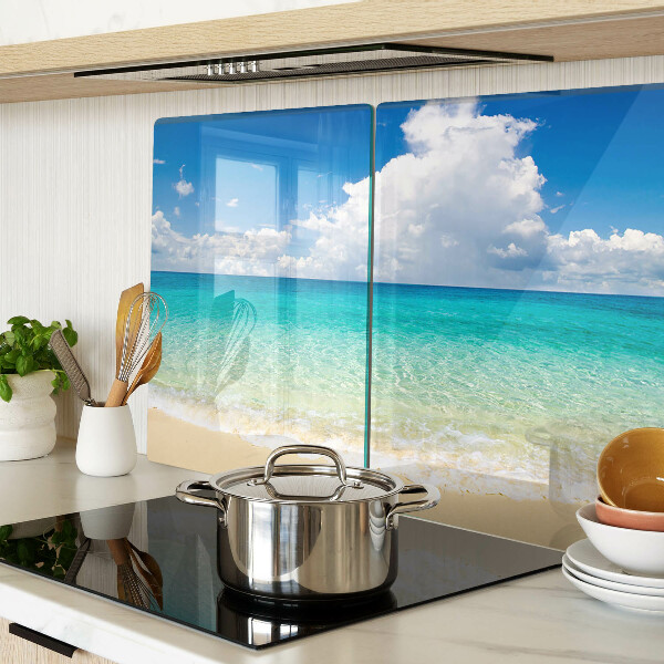 Snijplanken van glas Een strand met turquoise water en wolken.