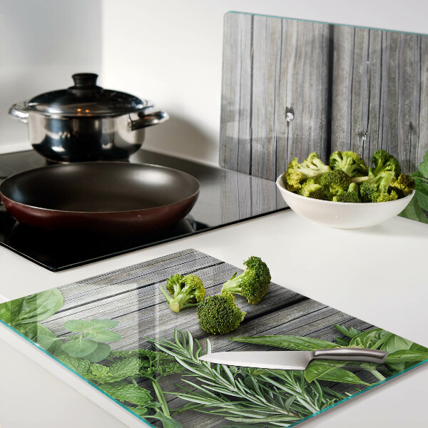 Snijplanken van glas Groene kruiden op een houten achtergrond