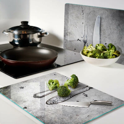 Snijplanken glas Bestek op een betonnen achtergrond