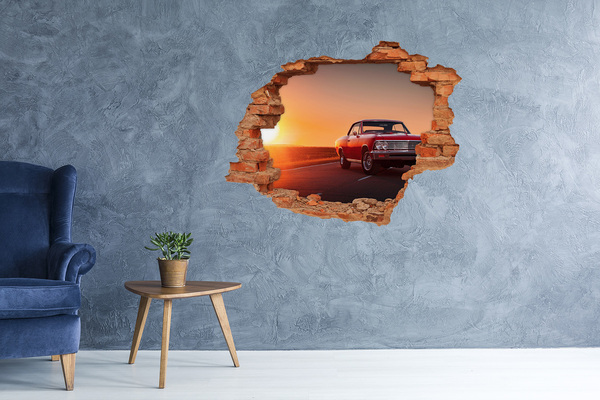Grote 3D muursticker gat in de muur Klassieke auto tegen de achtergrond van een zonsondergang