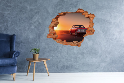 Grote 3D muursticker gat in de muur Klassieke auto tegen de achtergrond van een zonsondergang