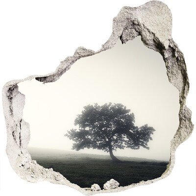 3D muursticker effect gat in de muur Een mistige open plek met een eenzame boom.