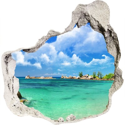 3D muursticker effect gat in de muur Een paradijselijk strand met turquoise water.