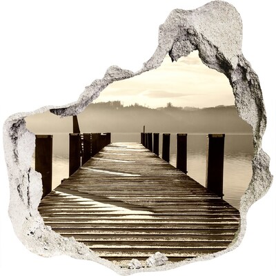 3D muursticker effect gat in de muur Een steiger boven kalm water