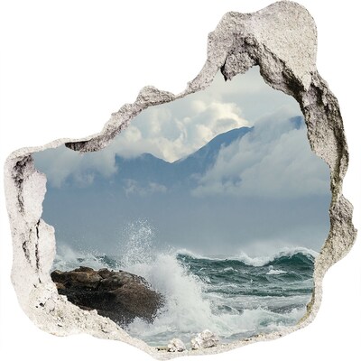 3D muursticker effect gat in de muur Stormachtige zee met berglandschap op de achtergrond.