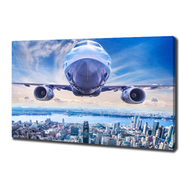 Schilderij op canvas Een vliegtuig boven de stad