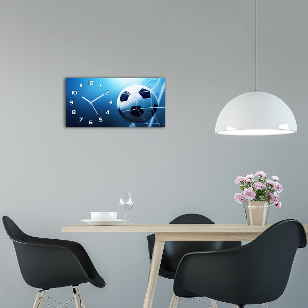 Langwerpige wandklok van glas De bal ligt in het doel.