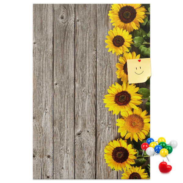 Memobord van kurk met zonnebloemen op een houten achtergrond