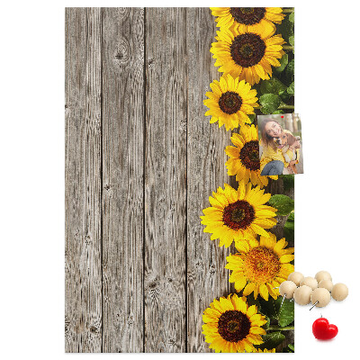 Memobord van kurk met zonnebloemen op een houten achtergrond