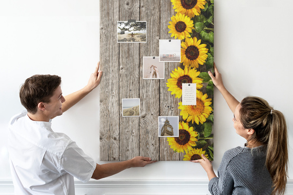 Memobord van kurk met zonnebloemen op een houten achtergrond