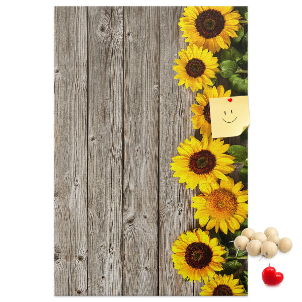 Memobord van kurk met zonnebloemen op een houten achtergrond