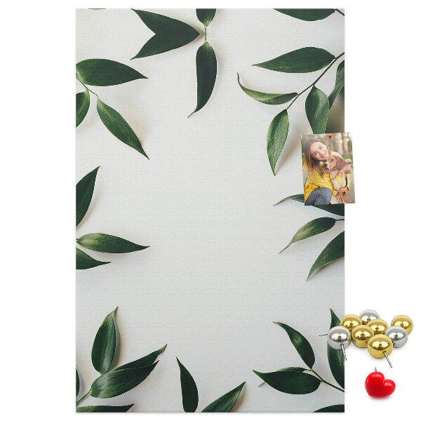 Memobord van kurk met groene bladeren op een lichte achtergrond