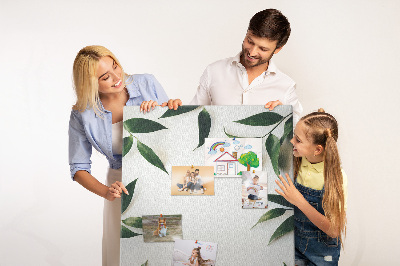 Memobord van kurk met groene bladeren op een lichte achtergrond