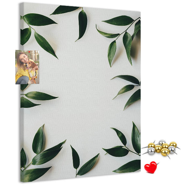 Memobord van kurk met groene bladeren op een lichte achtergrond