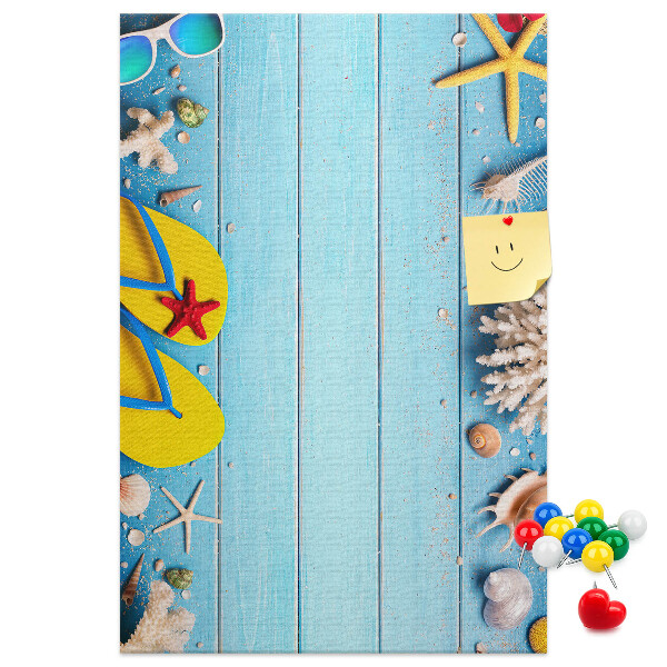 Memobord van kurk met zomerse strandaccessoires op een blauwe achtergrond