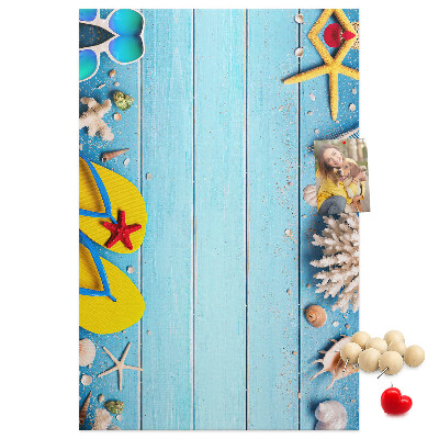 Memobord van kurk met zomerse strandaccessoires op een blauwe achtergrond
