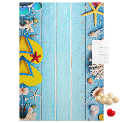 Memobord van kurk met zomerse strandaccessoires op een blauwe achtergrond