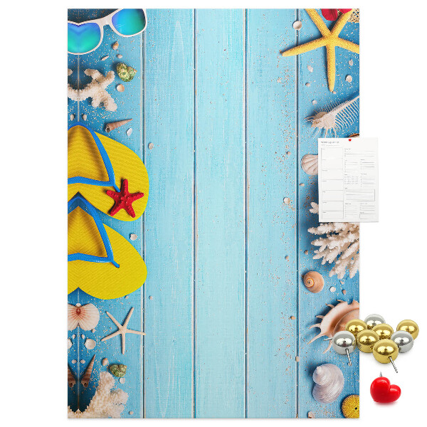 Memobord van kurk met zomerse strandaccessoires op een blauwe achtergrond