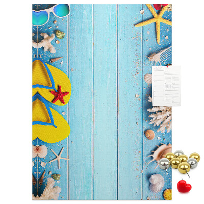 Memobord van kurk met zomerse strandaccessoires op een blauwe achtergrond