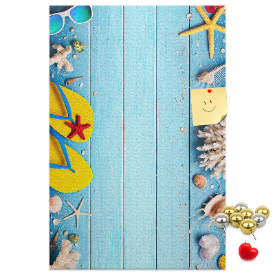 Memobord van kurk met zomerse strandaccessoires op een blauwe achtergrond