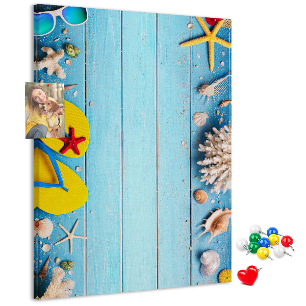 Memobord van kurk met zomerse strandaccessoires op een blauwe achtergrond