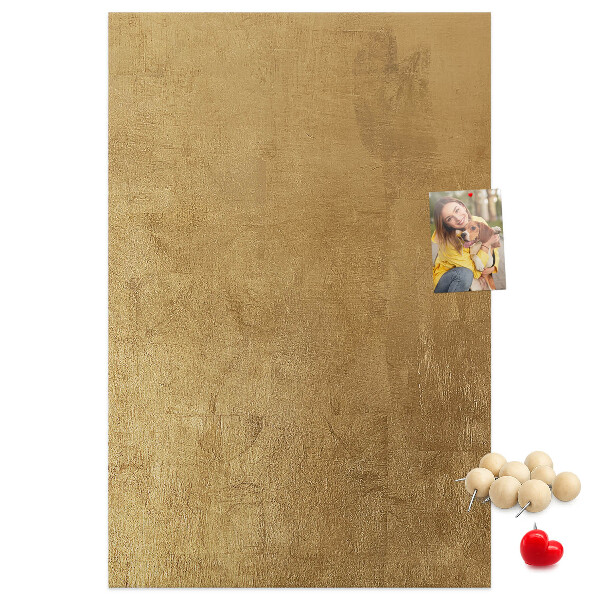 Kurk memobord met goudkleurig papier en gekleurde spelden