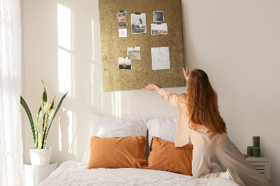 Kurk memobord met goudkleurig papier en gekleurde spelden
