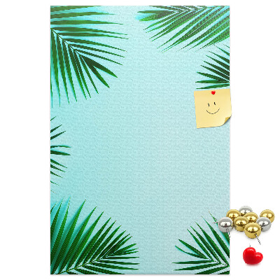 Memobord van kurk met palmbladeren op een blauwe achtergrond