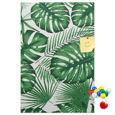 Prikbord van kurk met een print van Monstera-bladeren op een lichte achtergrond
