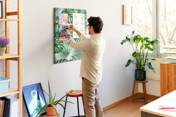 Prikbord van kurk met een print van Monstera-bladeren op een lichte achtergrond