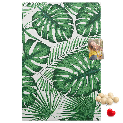 Prikbord van kurk met een print van Monstera-bladeren op een lichte achtergrond