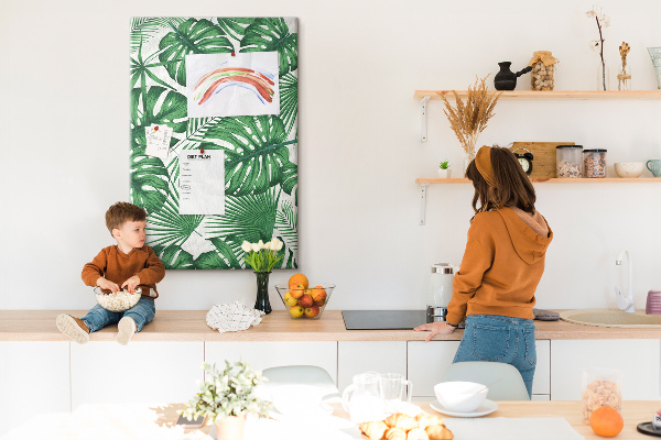 Prikbord van kurk met een print van Monstera-bladeren op een lichte achtergrond
