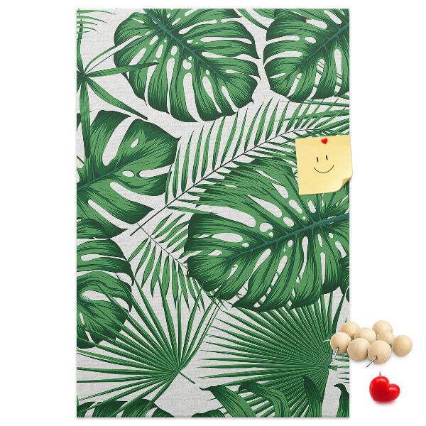 Prikbord van kurk met een print van Monstera-bladeren op een lichte achtergrond