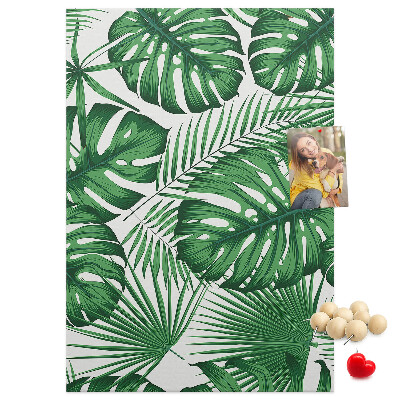 Prikbord van kurk met een print van Monstera-bladeren op een lichte achtergrond