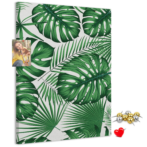 Prikbord van kurk met een print van Monstera-bladeren op een lichte achtergrond