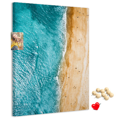 Kurken memobord met een afbeelding van een strand met golvende zee en mensen