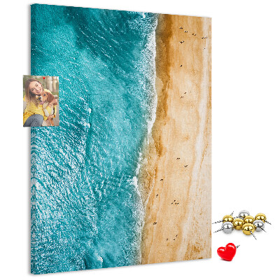 Kurken memobord met een afbeelding van een strand met golvende zee en mensen