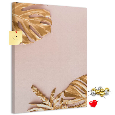 Memobord van kurk met gouden blaadjes op een zachtroze achtergrond