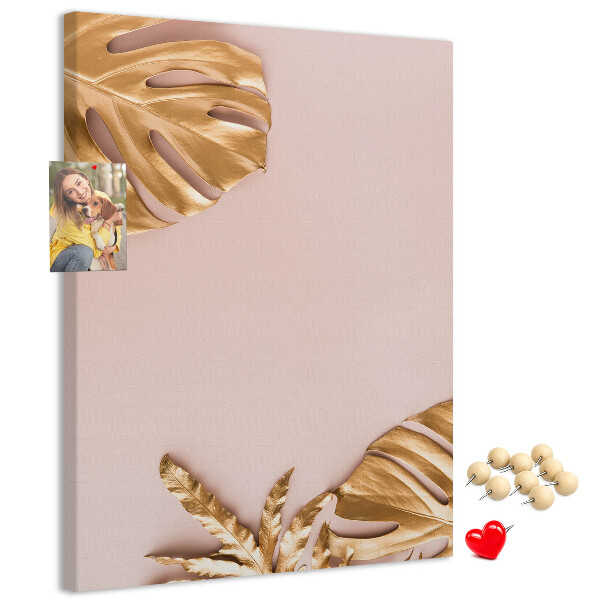 Memobord van kurk met gouden blaadjes op een zachtroze achtergrond